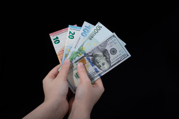 Hand holding American dollar  isolated on black background