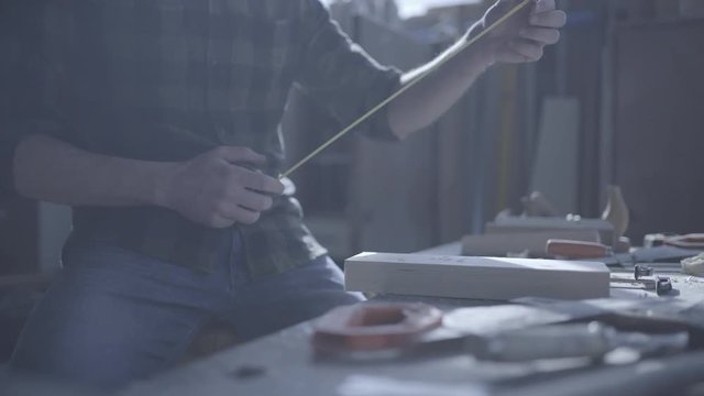 Handsome man in his fourties working with tools and wood at his workplace