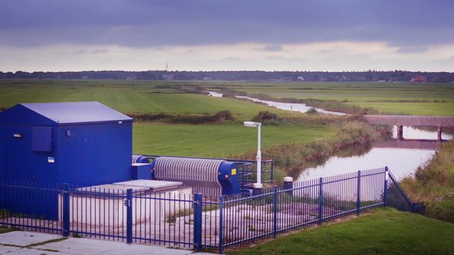 Dutch sea dike sluice gate polder drainage water outlet overcast view towards main channel