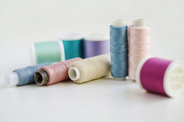 Bobbins of blue, green, purple, violet, lilac, pink thread for sewing. Copy space