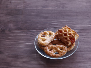 Homemade cookies on a transparent glass plate on a wooden table
