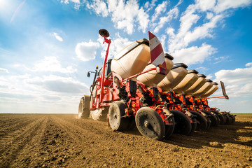 Farmer seeding, sowing crops at field. Sowing is the process of planting seeds in the ground as...