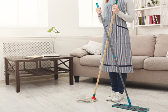 Unrecognizable woman cleaning house with mops