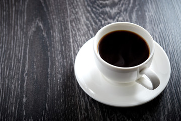 White Cup of black hot coffee on dark wooden background