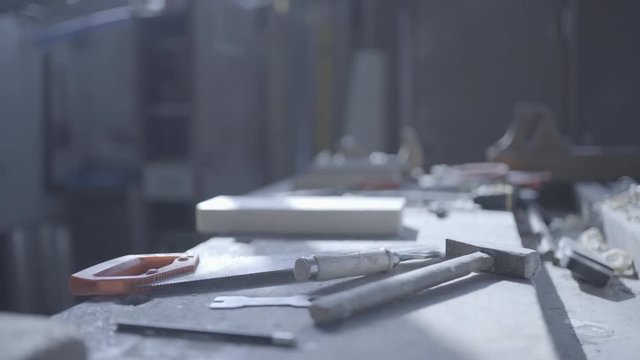 Handsome man in his fourties working with wood in his workshop