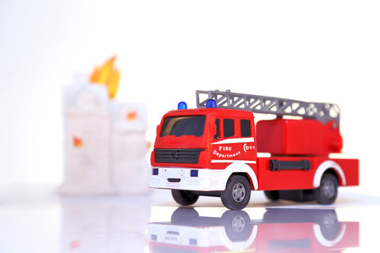 Feuerwehrauto im Vordergrund brennendes haus usncharf im Hintergrund
