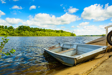 Obraz premium Minimalistic horizontal landscape with a boat on a calm river, green forest and cloudy sky. It's perfect.