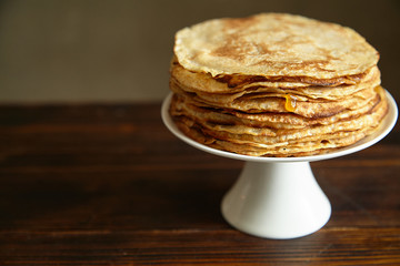Crepes cake with orange jam and honey on white cake stand with text space. Pancake breakfast concept