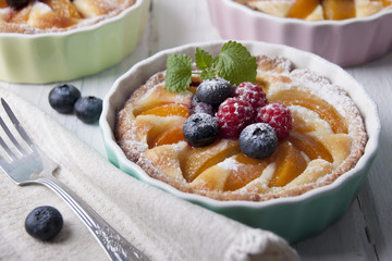 Tarts with curd cream, apricot and berries in ceramic form