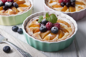 Tarts with curd cream, apricot and berries in ceramic form
