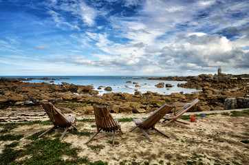 Beach chair in front beautiful rocky beach in Brittany, France