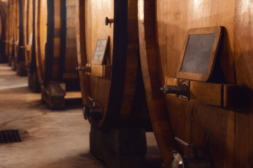 Fototapeta na wymiar Historic cellar in Piedmont, Italy, with slavonian oak wooden barrels for the the aging of red wines