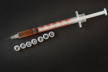  syringe with liquid, inscription vaccine from letters