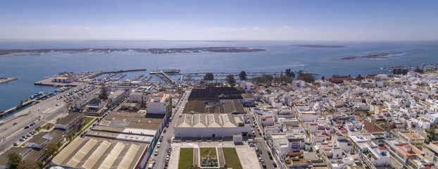 Aerial daytime view of Olhao downtown and Marina seascape, waterfront to Ria Formosa natural park. Algarve.