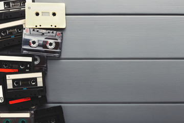 Vintage audio cassettes border on gray planks background