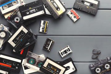 Vintage audio cassettes border on gray planks background