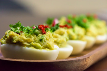 Boiled eggs stuffed with avocado paste with parsley, chili and radish - healthy breakfast- macro