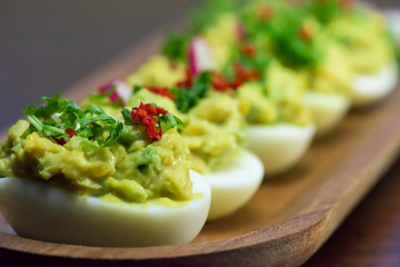 Boiled eggs stuffed with avocado paste with parsley, chili and radish - healthy breakfast- macro