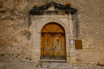 Fototapeta na wymiar La porte sculptée en bois d'ancienne église en Provence, village de Simiane-la-Rotonte. France.