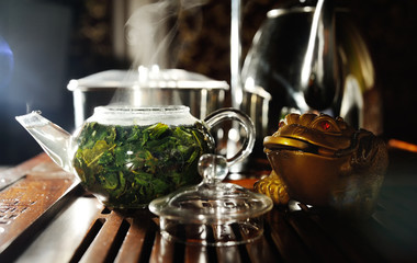 Green herbal tea in a glass teapot on a tea table. tea ceremony