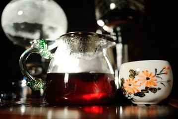 Kettle with red tea close-up on a tea table