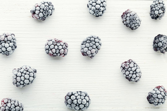 Frozen blackberries on white wooden table