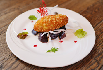 appetizing cutlet in battered beetroot on a white plate