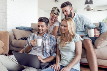 Happy friends with laptop watching a funny video.