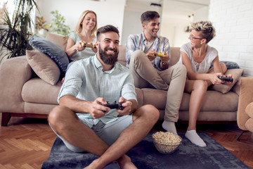 Obraz premium Excited friends playing video games at home.