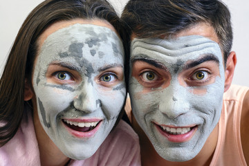 Emotional large portrait of a married couple in masks for the face of clay. day Spa, Wellness,...