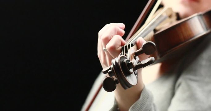 classical musician playing baroque violin on a black background - hands closeup live action concept