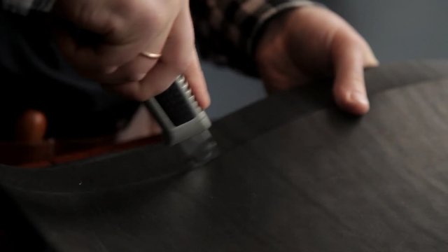 A master from a leather rudder cuts billets to make a belt. Procedure for the manufacture of leather belts.