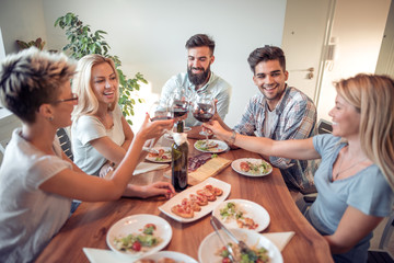Group of friends enjoying meal at home together.