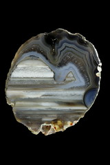 Cross section of agate. Multicolored silica bands colored with metal oxides are visible....