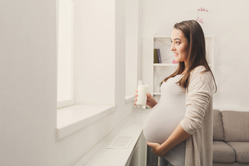 Fototapeta na wymiar Pregnant woman drinking glass of milk copy space