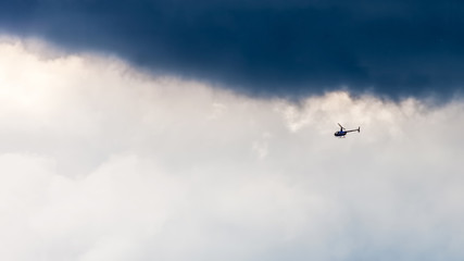 Helicopter in sky on storm background
