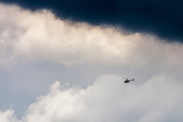 Fototapeta na wymiar Helicopter in sky on storm background