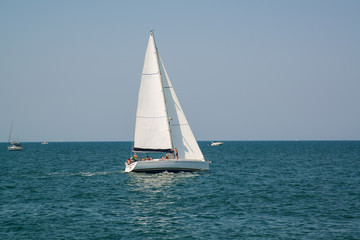 White yacht in the open azure sea near the resort of Rimini, Italy.