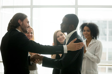 Company boss promoting african male employee with handshake showing gratitude, partnership or...