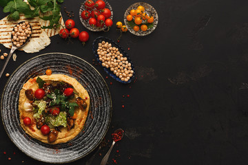 Hummus with vegetables and seafood on black background