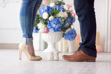 between the feet of the father and mother are baby booties