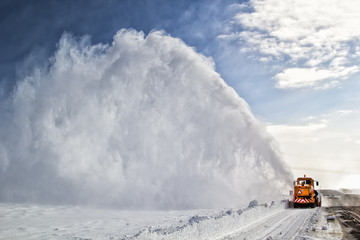 Snow-covered road cleaning by snow removal machine.
