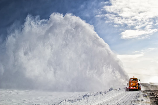 Snow-covered road cleaning by snow removal machine.