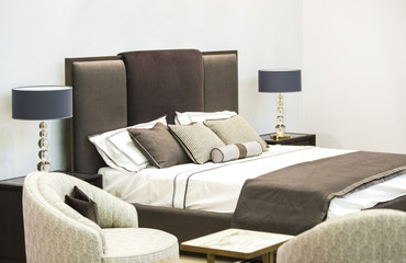 Modern luxury interior of the bedroom. Design of a room in a hotel with a bed and original table lamps