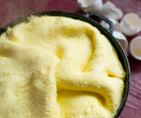 Freshly cooked omelette in a frying pan. Steam rises from the omelet.