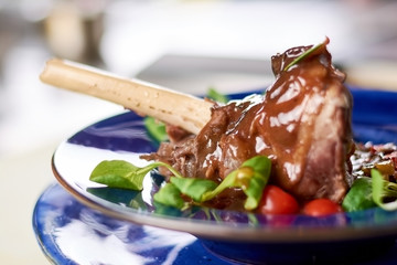 Braised lamb shank with vegetable ratatouille. Slow cooked lamb shank in restaurant close up....