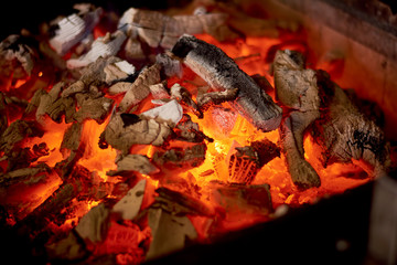 Glowing hot charcoal in bbq stove. Charcoal burning fire in stove for cooking food. Cuisine and food preparing concept.