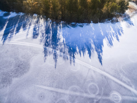 Aerial view: Ice on dark lake