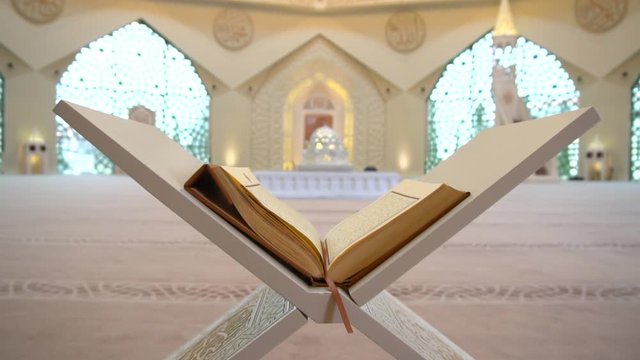 A man is reading Quran on the reading desk in a mosque.