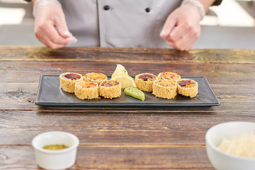 Sushi unagi set on wooden table. Roll unagi furay at japanese restaurant kitchen. Chef cooked sushi with eel and avocado at professional kitchen.